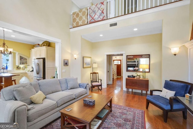 180 Shadow Wood Bnd, Saint Simons, GA 31522 - living room featuring a high ceiling, a chandelier, and wood finished floors