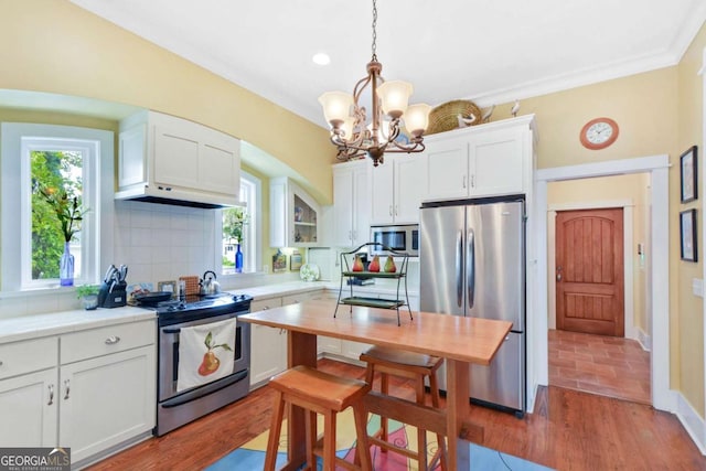 180 Shadow Wood Bnd, Saint Simons, GA 31522 - kitchen with appliances with stainless steel finishes, white cabinets, light countertops, tasteful backsplash, and a chandelier