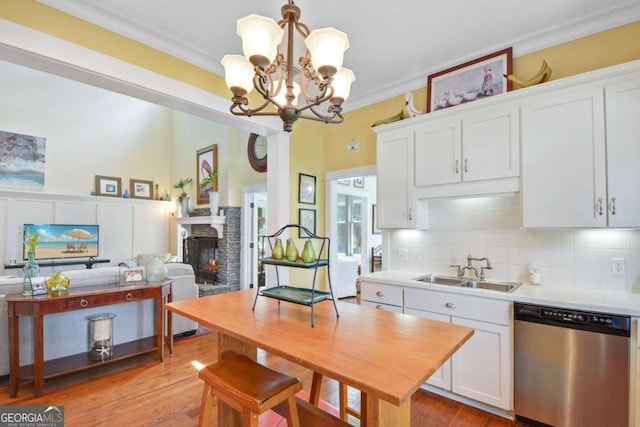 180 Shadow Wood Bnd, Saint Simons, GA 31522 - kitchen featuring dishwasher, white cabinetry, ornamental molding, decorative backsplash, and a fireplace