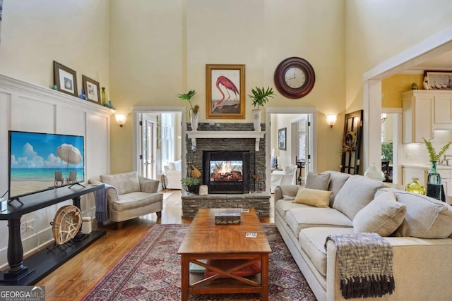 180 Shadow Wood Bnd, Saint Simons, GA 31522 - living room with a towering ceiling, a stone fireplace, and wood finished floors
