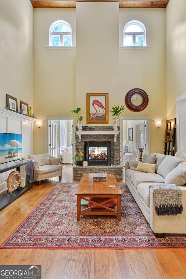 180 Shadow Wood Bnd, Saint Simons, GA 31522 - living area with a towering ceiling, healthy amount of natural light, wood-type flooring, and a fireplace