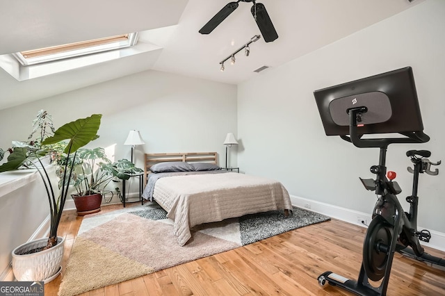 1078 Piedmont Ave NE Unit 206, Atlanta, GA 30309 - bedroom featuring a skylight, wood finished floors, rail lighting, vaulted ceiling, and ceiling fan