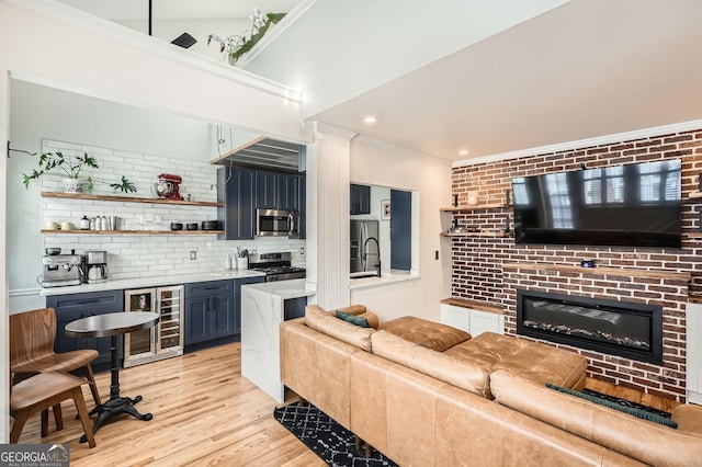 1078 Piedmont Ave NE Unit 206, Atlanta, GA 30309 - living area with beverage cooler, crown molding, light wood-style floors, a glass covered fireplace, and recessed lighting