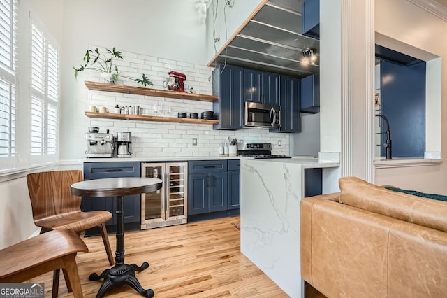 1078 Piedmont Ave NE Unit 206, Atlanta, GA 30309 - indoor bar with stainless steel microwave, wine cooler, backsplash, light wood-type flooring, and stove