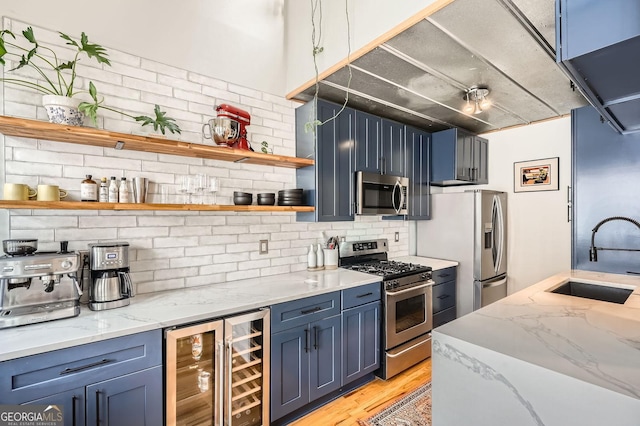 1078 Piedmont Ave NE Unit 206, Atlanta, GA 30309 - kitchen with appliances with stainless steel finishes, wine cooler, open shelves, tasteful backsplash, and blue cabinetry