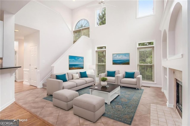 2330 Springmonte Pl, Cumming, GA 30041 - living room with light tile patterned floors, healthy amount of natural light, a towering ceiling, a fireplace, and a ceiling fan