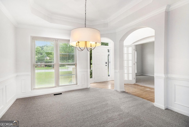 2330 Springmonte Pl, Cumming, GA 30041 - carpeted empty room with a raised ceiling, a chandelier, arched walkways, wainscoting, and crown molding