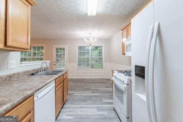 541 Shadow Valley Ct, Lithonia, GA 30058 - kitchen with white appliances, a sink, light wood-style flooring, a chandelier, and healthy amount of natural light