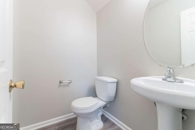 541 Shadow Valley Ct, Lithonia, GA 30058 - half bathroom with toilet, wood finished floors, and baseboards