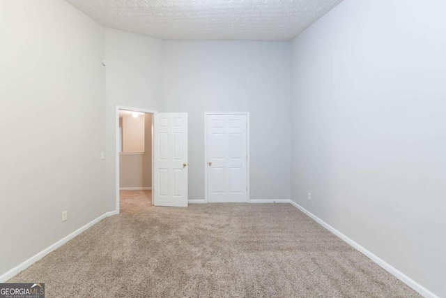 541 Shadow Valley Ct, Lithonia, GA 30058 - spare room featuring light carpet, a textured ceiling, baseboards, and a towering ceiling