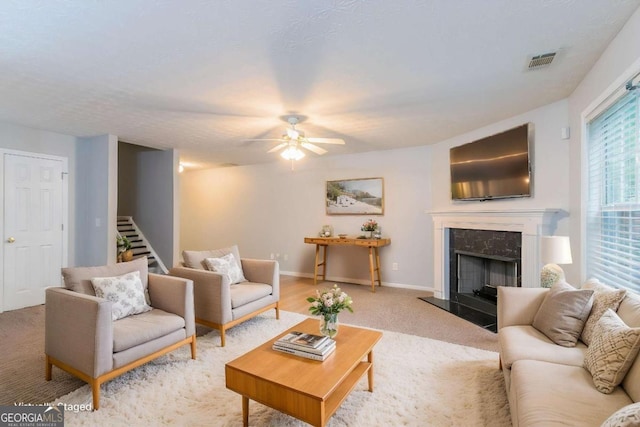 541 Shadow Valley Ct, Lithonia, GA 30058 - living area featuring stairway, ceiling fan, a high end fireplace, baseboards, and light carpet