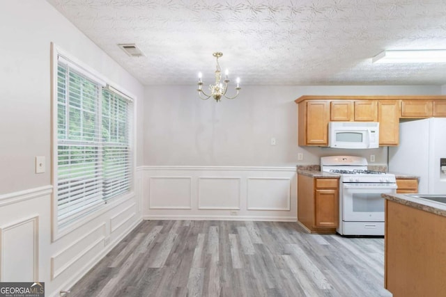 541 Shadow Valley Ct, Lithonia, GA 30058 - kitchen with white appliances, a chandelier, light wood-style flooring, a wainscoted wall, and a decorative wall