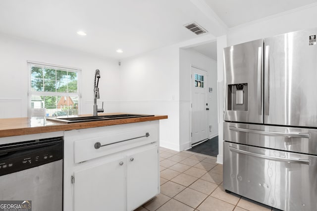 1844 Stanton St, Decatur, GA 30032 - kitchen featuring appliances with stainless steel finishes, wooden counters, white cabinetry, a sink, and light tile patterned floors