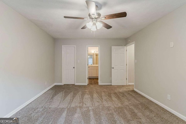 5352 Windfern Ct, Stone Mountain, GA 30088 - unfurnished bedroom featuring carpet, baseboards, connected bathroom, and ceiling fan
