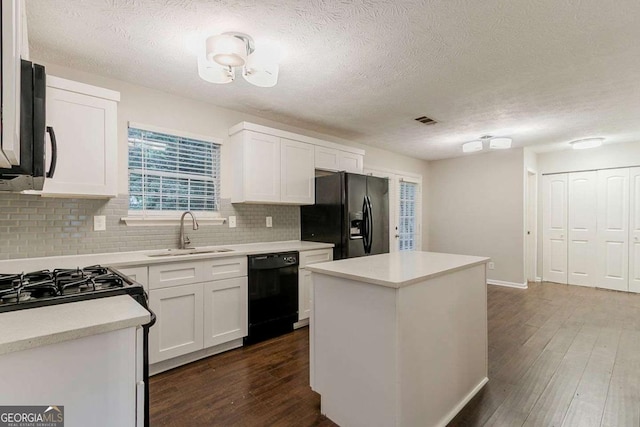 5352 Windfern Ct, Stone Mountain, GA 30088 - kitchen featuring black appliances, a sink, decorative backsplash, light countertops, and dark wood-type flooring