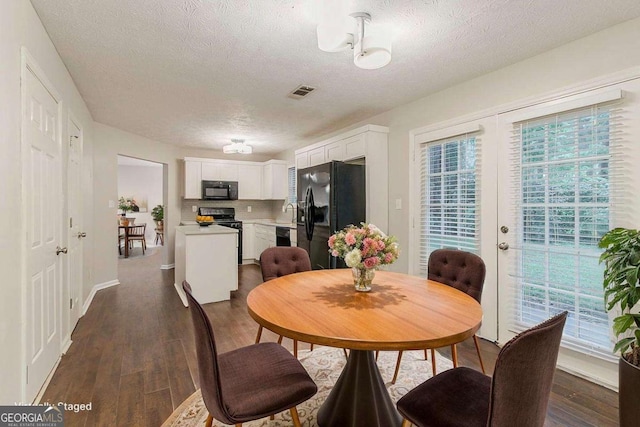 5352 Windfern Ct, Stone Mountain, GA 30088 - dining area featuring a textured ceiling, plenty of natural light, dark wood-style floors, and baseboards