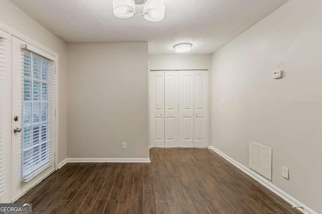 5352 Windfern Ct, Stone Mountain, GA 30088 - unfurnished bedroom with wood finished floors, a chandelier, baseboards, a textured ceiling, and a closet