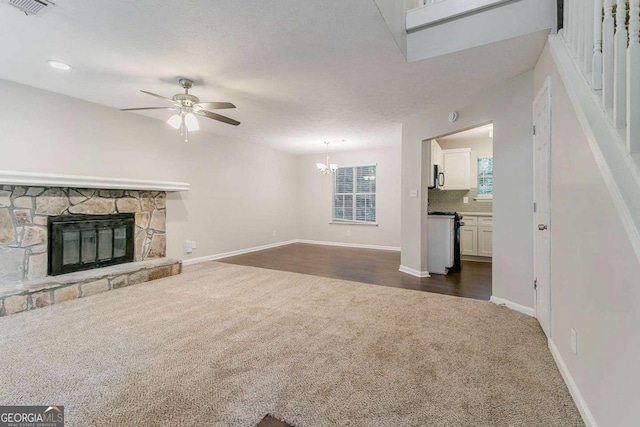 5352 Windfern Ct, Stone Mountain, GA 30088 - unfurnished living room with dark colored carpet, a ceiling fan, a fireplace, a chandelier, and baseboards