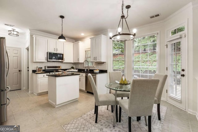 5860 Fairway View Dr, Suwanee, GA 30024 - kitchen featuring appliances with stainless steel finishes, a center island, tasteful backsplash, ornamental molding, and plenty of natural light