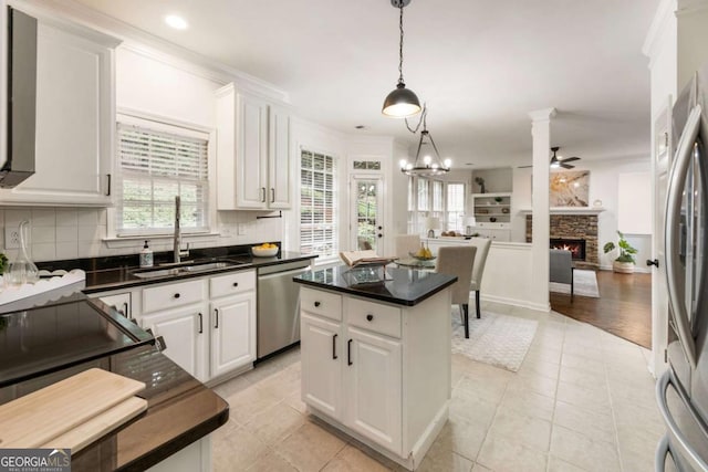 5860 Fairway View Dr, Suwanee, GA 30024 - kitchen with appliances with stainless steel finishes, open floor plan, a stone fireplace, a ceiling fan, and decorative backsplash