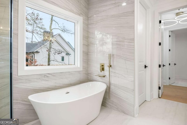 1050 Carnoustie, Greensboro, GA 30642 - full bathroom with a freestanding tub, healthy amount of natural light, and tile walls