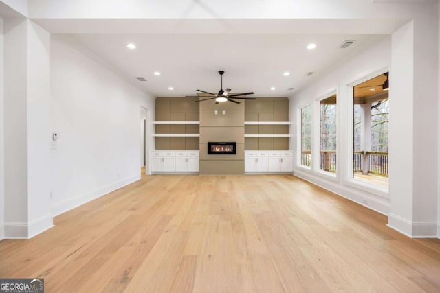 1050 Carnoustie, Greensboro, GA 30642 - unfurnished living room with a ceiling fan, a large fireplace, light wood-style floors, and recessed lighting