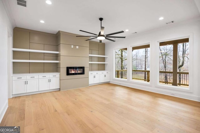 1050 Carnoustie, Greensboro, GA 30642 - unfurnished living room featuring ceiling fan, light wood finished floors, a glass covered fireplace, and recessed lighting