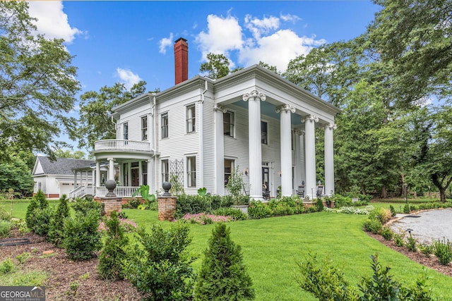 766 E Ave, Madison, GA 30650 - view of front of home featuring a porch, a chimney, a front yard, and a balcony