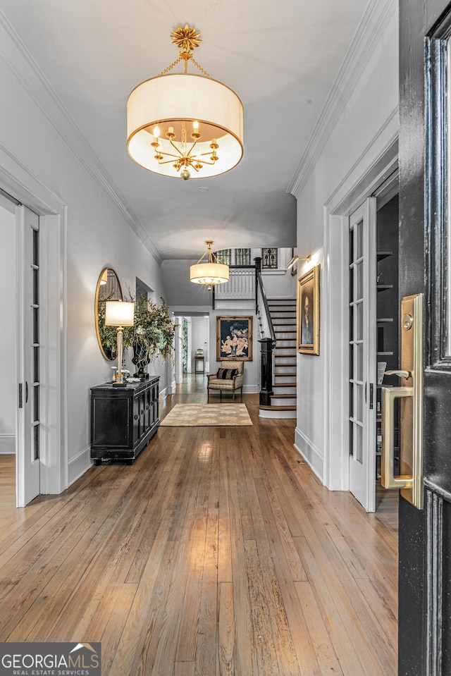 766 E Ave, Madison, GA 30650 - hallway featuring stairs, a chandelier, wood-type flooring, and crown molding