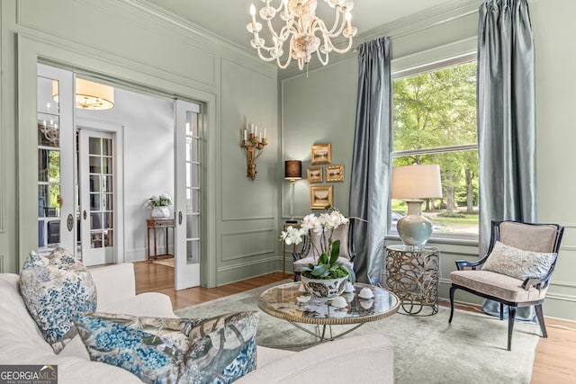 766 E Ave, Madison, GA 30650 - living area featuring a chandelier, wood finished floors, ornamental molding, and a decorative wall