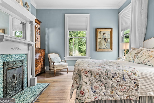 766 E Ave, Madison, GA 30650 - bedroom featuring a fireplace with flush hearth, hardwood / wood-style flooring, multiple windows, and crown molding