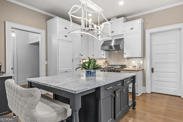 766 E Ave, Madison, GA 30650 - kitchen with wall chimney range hood, a chandelier, white cabinetry, backsplash, and recessed lighting