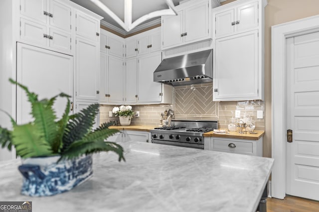 766 E Ave, Madison, GA 30650 - kitchen featuring extractor fan, stove, white cabinets, decorative backsplash, and light stone counters