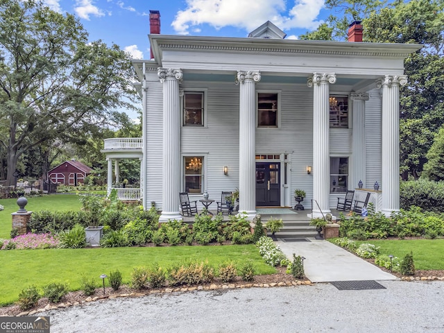 766 E Ave, Madison, GA 30650 - neoclassical home featuring covered porch, a chimney, and a front lawn