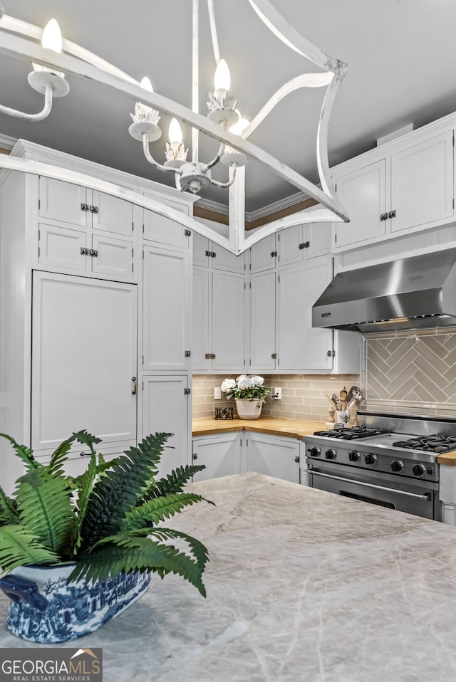 766 E Ave, Madison, GA 30650 - kitchen featuring extractor fan, stainless steel stove, backsplash, a chandelier, and white cabinetry