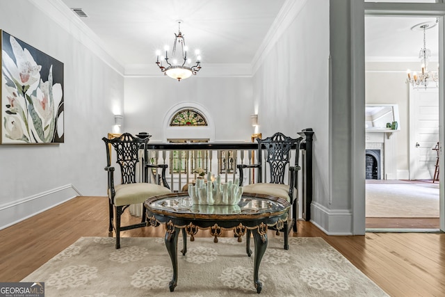 766 E Ave, Madison, GA 30650 - living area featuring a chandelier, wood finished floors, crown molding, and a fireplace