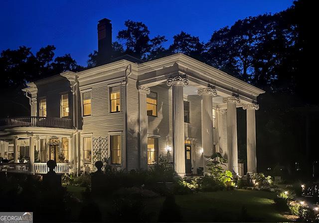 766 E Ave, Madison, GA 30650 - back of house at twilight featuring a porch and a chimney