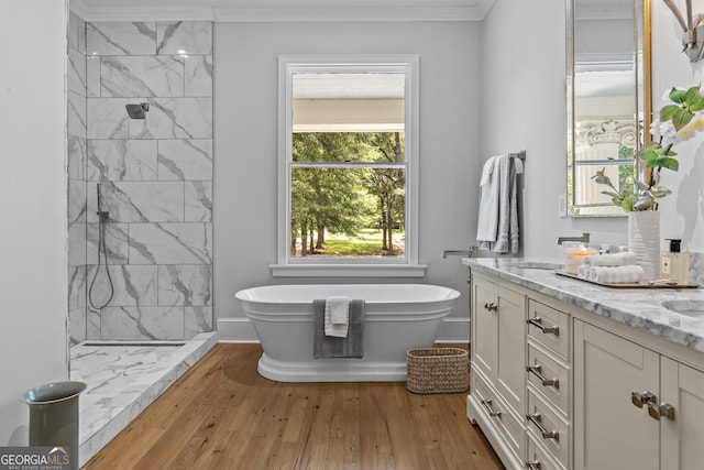 766 E Ave, Madison, GA 30650 - bathroom featuring vanity, a soaking tub, a tile shower, wood finished floors, and ornamental molding