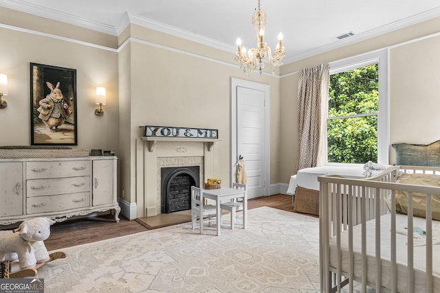 766 E Ave, Madison, GA 30650 - bedroom featuring wood finished floors, a chandelier, ornamental molding, a fireplace with raised hearth, and a crib
