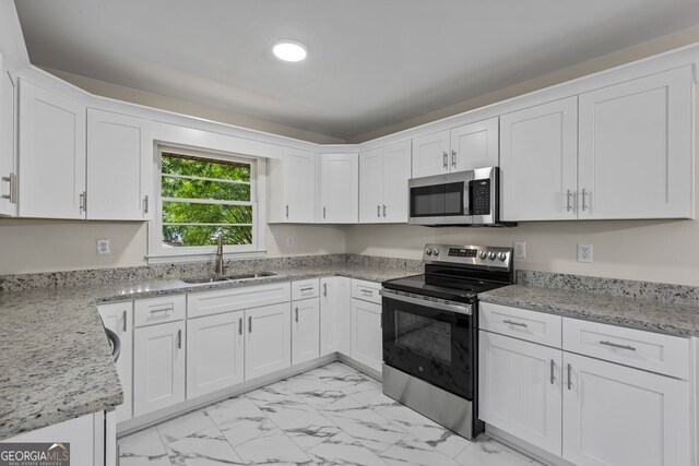 1124 Ponderosa Park Dr, Forest Park, GA 30297 - kitchen with stainless steel appliances, a sink, light marble finish flooring, white cabinetry, and light stone counters