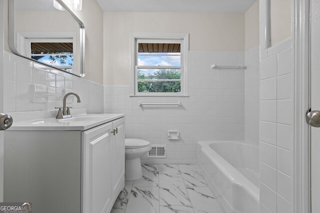 1124 Ponderosa Park Dr, Forest Park, GA 30297 - full bath with tile walls, vanity, toilet, marble look tiles, and wainscoting