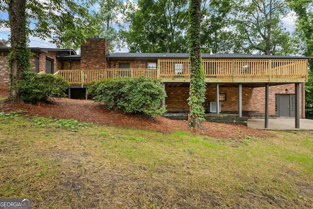 1124 Ponderosa Park Dr, Forest Park, GA 30297 - back of property featuring brick siding, a chimney, a wooden deck, and a lawn