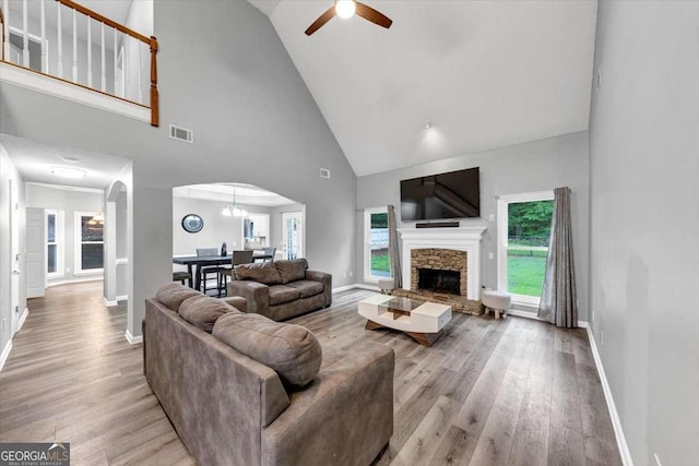 3190 Water Brook Dr SW, Conyers, GA 30094 - living room with arched walkways, a ceiling fan, light wood-type flooring, high vaulted ceiling, and baseboards