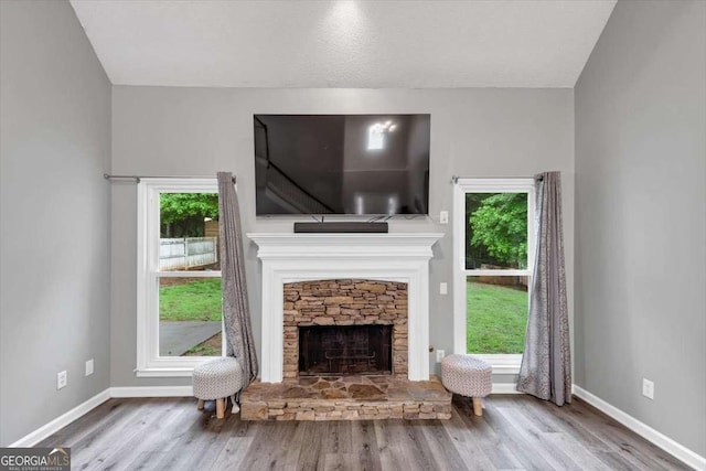 3190 Water Brook Dr SW, Conyers, GA 30094 - living room with wood finished floors, baseboards, a stone fireplace, and plenty of natural light