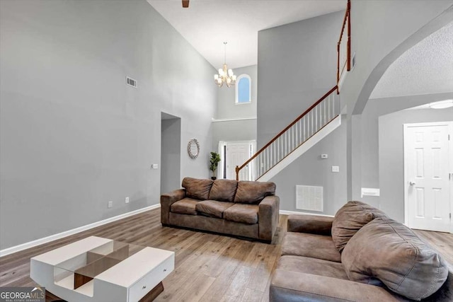 3190 Water Brook Dr SW, Conyers, GA 30094 - living area featuring high vaulted ceiling, wood finished floors, arched walkways, baseboards, and a chandelier