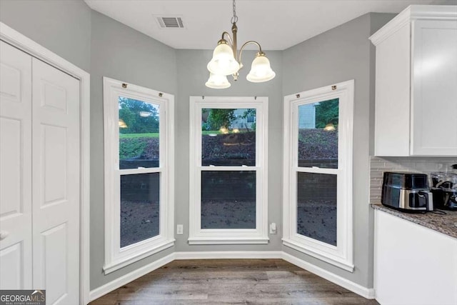 3190 Water Brook Dr SW, Conyers, GA 30094 - unfurnished dining area featuring a chandelier, dark wood-style floors, and baseboards