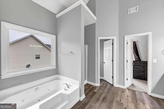 3190 Water Brook Dr SW, Conyers, GA 30094 - bathroom featuring a jetted tub, wood finished floors, and baseboards