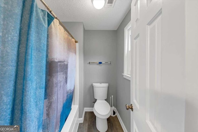 3190 Water Brook Dr SW, Conyers, GA 30094 - full bathroom featuring wood finished floors, toilet, baseboards, a textured ceiling, and shower / bath combo with shower curtain