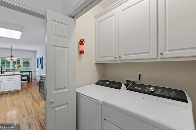 40 Costleys Bridge Dr, Oxford, GA 30054 - laundry area featuring cabinet space, washer and dryer, light wood finished floors, a skylight, and a chandelier