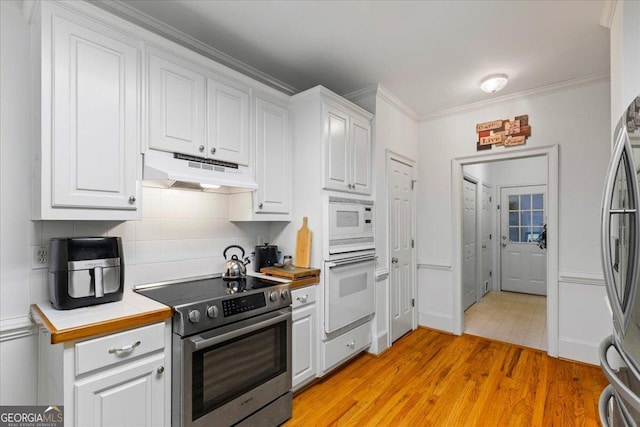 40 Costleys Bridge Dr, Oxford, GA 30054 - kitchen featuring stainless steel appliances, under cabinet range hood, white cabinetry, light wood-style floors, and ornamental molding